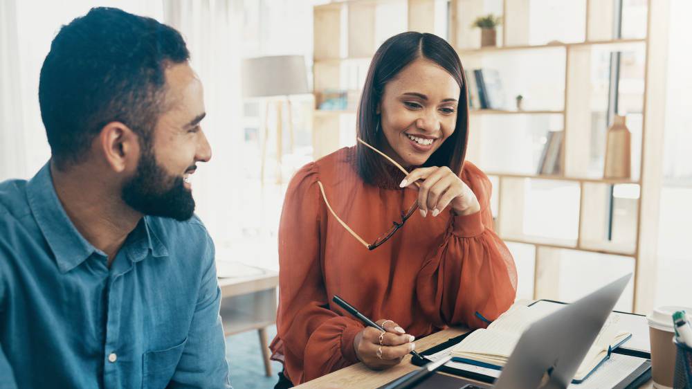 Two people working at a laptop