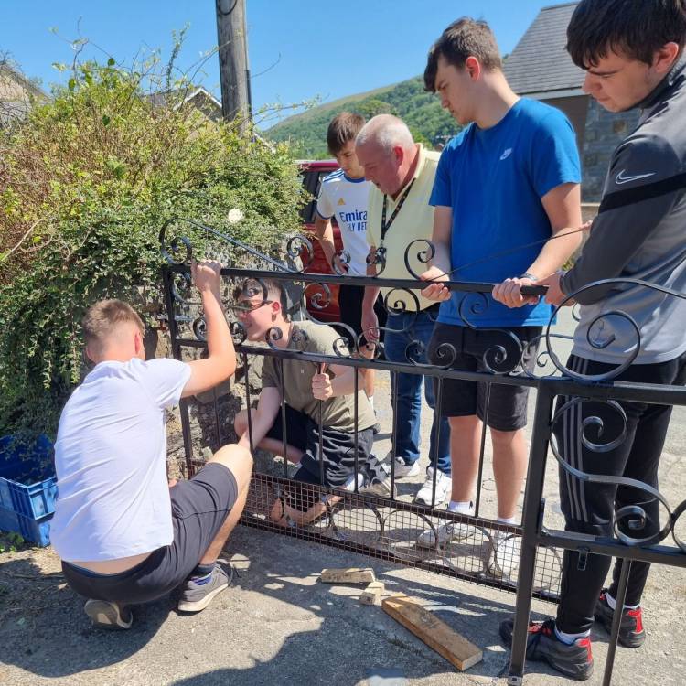 Students installing the gate with Gwyn Williams watching