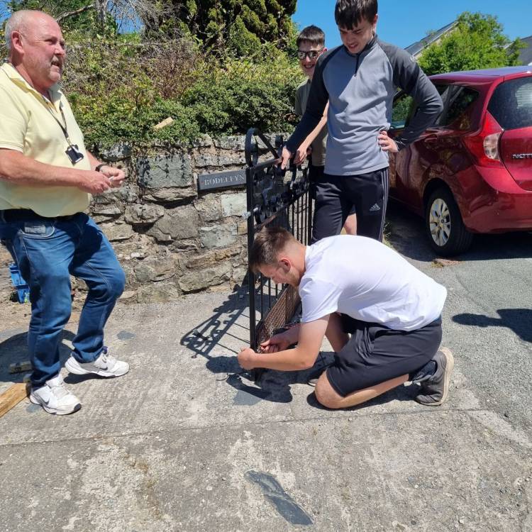 Students installing the gate with Gwyn Williams watching