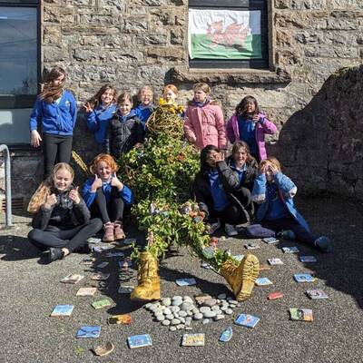 Ysgol y Talwrn learners with a sculpture of the giant Bendigeidfran made from foraged materials