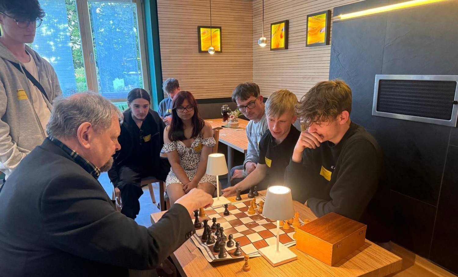 Students playing chess with Carl-August Heinz of HeinzGlas