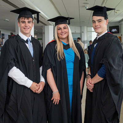 Three graduates smiling