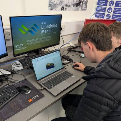 Students programming computer-aided design software Fusion on a laptop during an Autodesk workshop at Coleg Menai