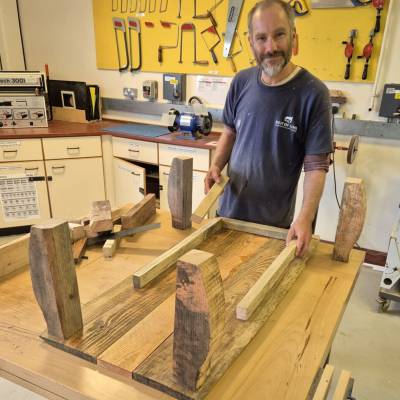 Multiply learner Jamie Walker with a coffee table he built in a Practical Woodworking and Numeracy Skills course