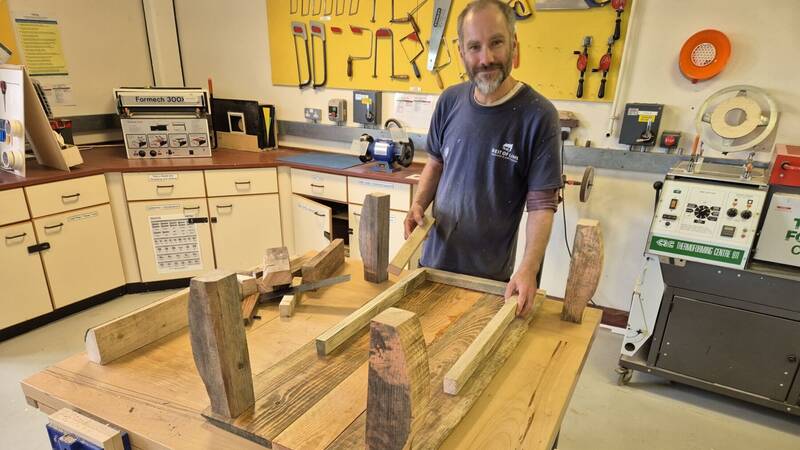 Multiply learner Jamie Walker with a coffee table he built in a Practical Woodworking and Numeracy Skills course