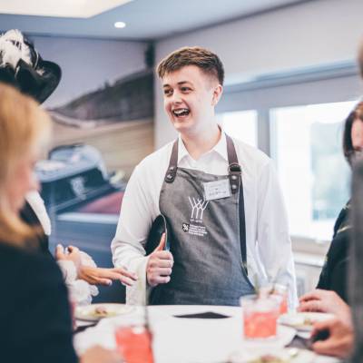 Former Coleg Meirion-Dwyfor student Jack Williams talking to guests while competing at the Young Waiter 2024 Welsh final