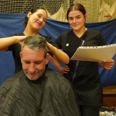 Coleg Meirion-Dwyfor hairdressing students giving a scalp massage at the Iechyd Da event in Dolgellau