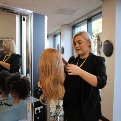 Heather Wynne practising her hairdressing on a mannequin in the salon at Coleg Llandrillo’s Rhyl campus