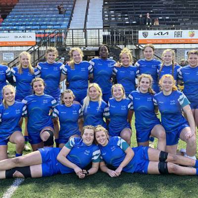 Grŵp Llandrillo Menai’s girls’ rugby academy team with coaches Andrew Williams and Lucy Brown