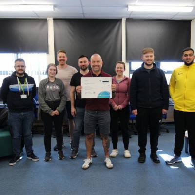 Lecturer Andrew Scott and students with a certificate recognising Coleg Llandrillo for 25 years of service with the Cisco Networking Academy