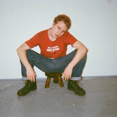 Former Coleg Menai student Barnaby Prendergast sitting on a stool he made